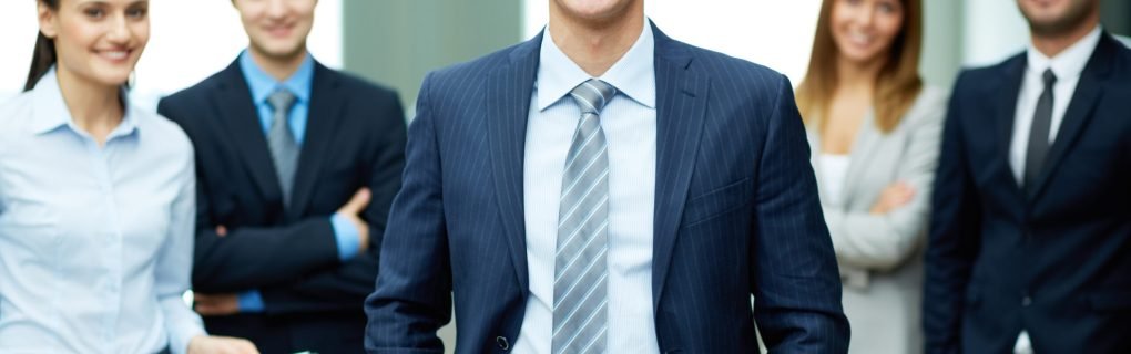 Group of friendly businesspeople with male leader in front